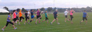 Runners training on a grass field